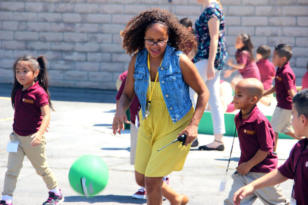 Ms. Guy plays soccer with some of her students. 
