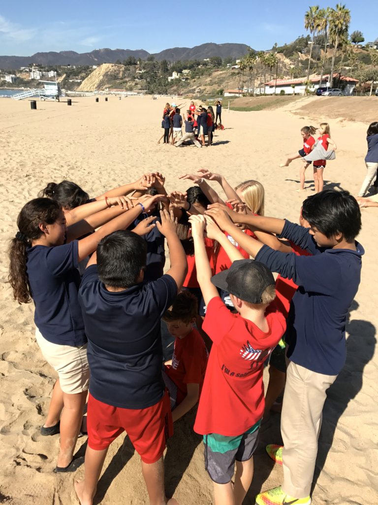 Students participate in team building activities at the beach cleanup.